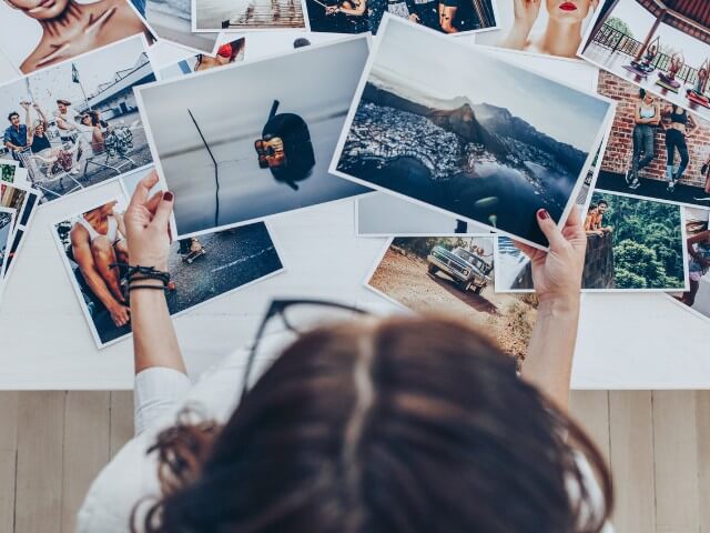 fotografa escolhendo fotos impressas em papel