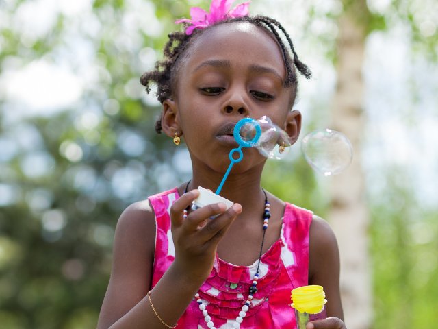ensaio fotográfico infantil criança soprando bolhas de sabão