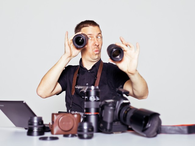 Fotografo profissioanal escolhendo equipamentos necessários para fotografia chiaroscuro. Mas está com ar de brincadeira