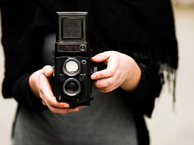 Mulher com uma câmera fotográfica portátil antiga
