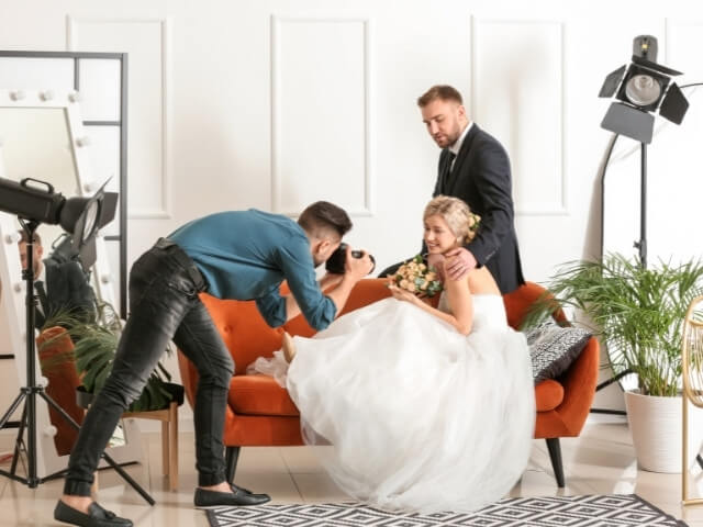 Fotografo masculino tirando fotos de um casal de noivos